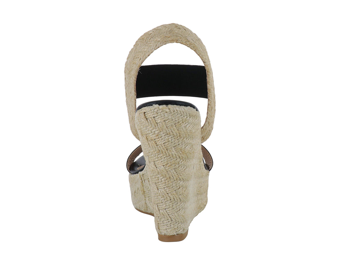 Sandalia de plataforma para mujer en color negro con base de yute beige y tira elástica en el tobillo.