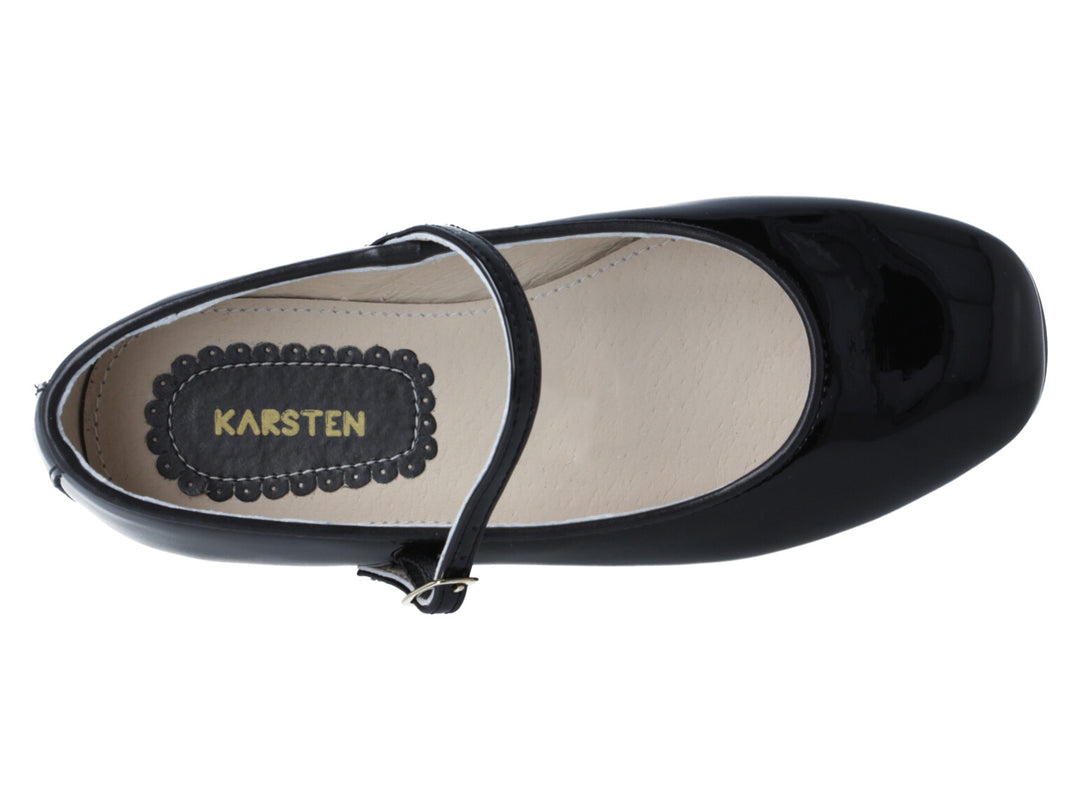 Zapato infantil de charol negro brillante con correa y hebilla metálica sobre fondo blanco.