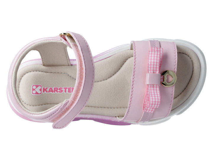 Sandalias rosas para niña con detalle de moño a cuadros y correa ajustable sobre fondo blanco.