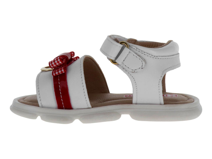 Sandalia blanca para Niña con detalle de moño rojo y correa ajustable en el tobillo.