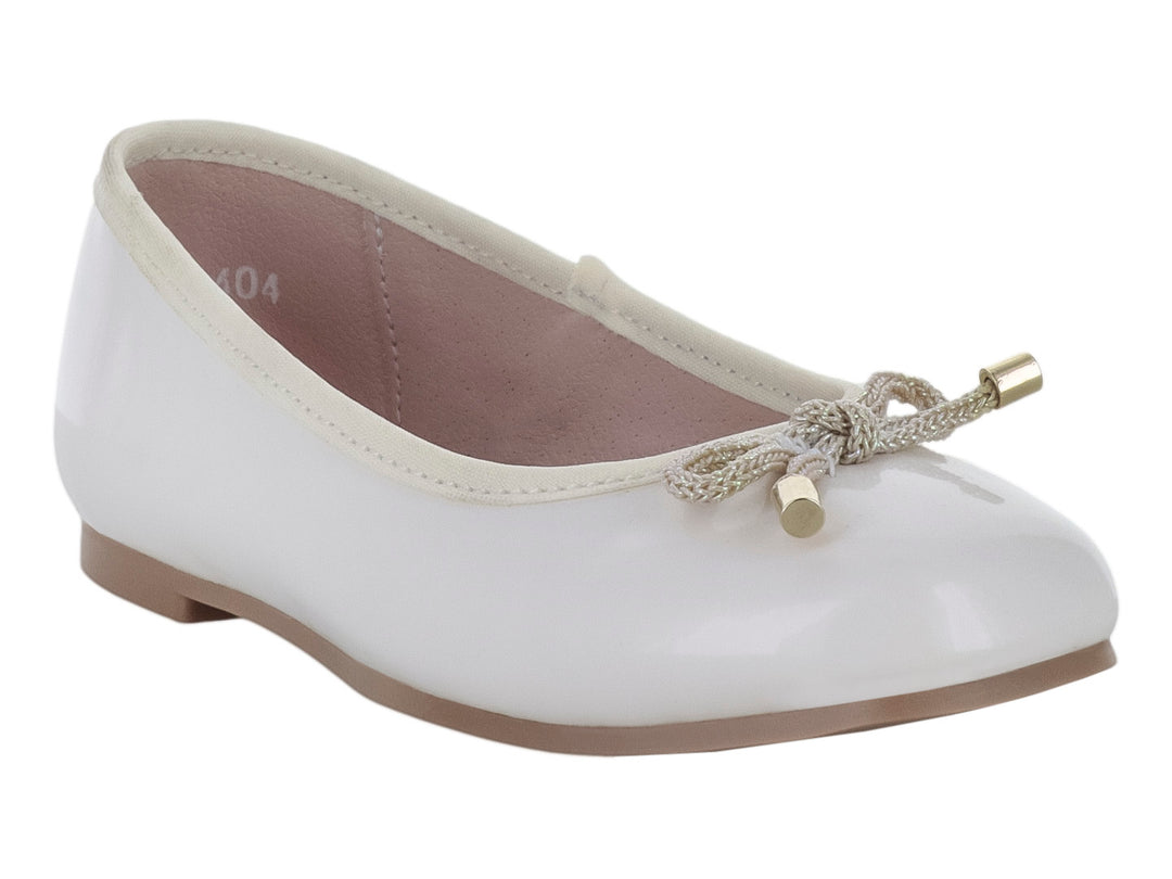 Zapato tipo balerina color hueso con acabado brillante y detalle de moño dorado en la punta para niña.