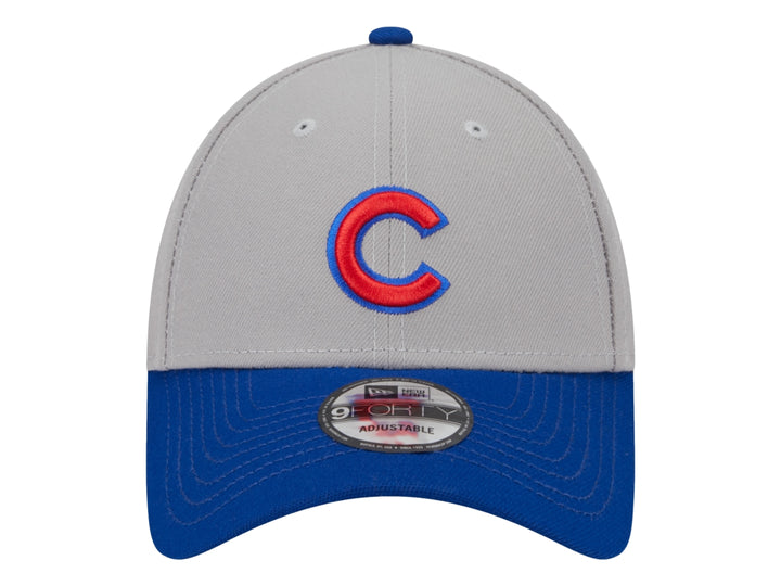 Gorra de béisbol New Era con corona gris, visera azul y logo rojo en el frente.