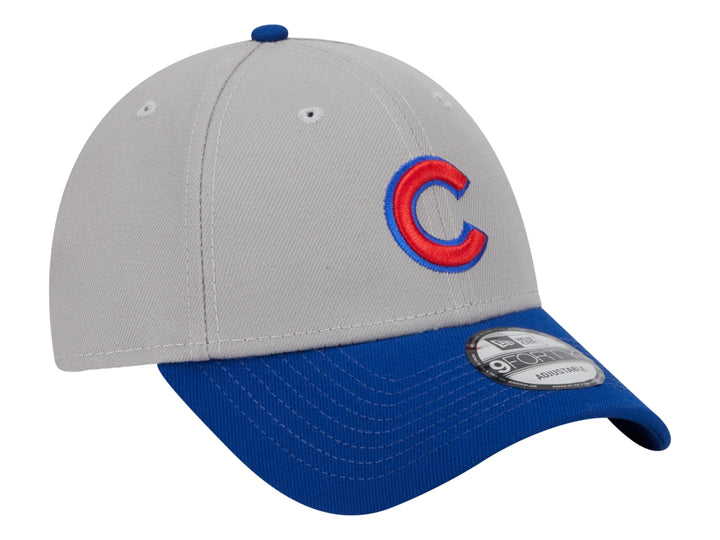 Gorra de béisbol New Era con corona gris, visera azul y logo rojo en el frente.