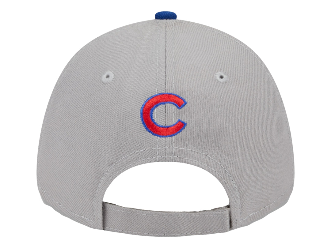 Gorra de béisbol New Era con corona gris, visera azul y logo rojo en el frente.