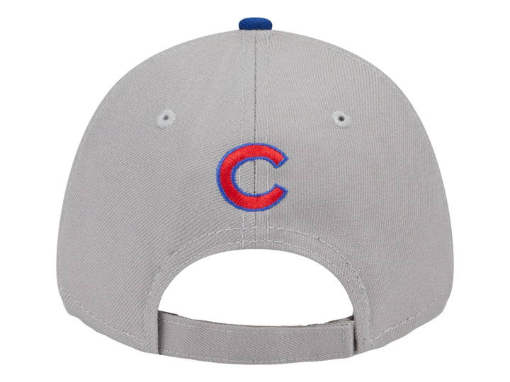 Gorra de béisbol New Era con corona gris, visera azul y logo rojo en el frente.