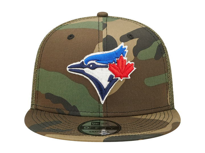 Gorra New Era con estampado de camuflaje en tonos verdes y cafés, visera plana y logo bordado al frente.