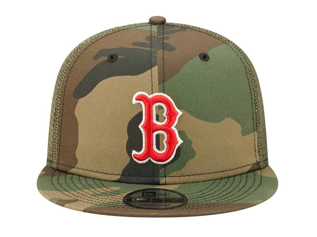Gorra New Era estilo trucker con estampado de camuflaje y logotipo bordado en rojo y blanco al frente.
