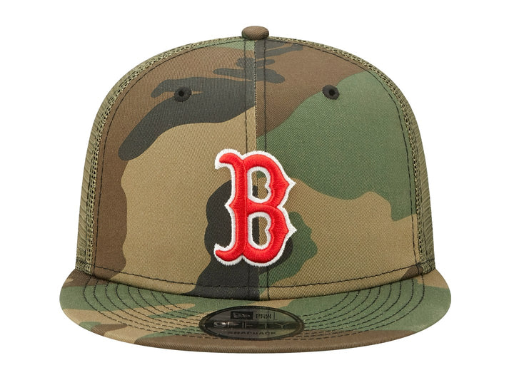 Gorra New Era estilo trucker con estampado de camuflaje y logotipo bordado en rojo y blanco al frente.