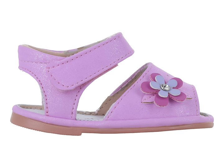 Sandalia rosa brillante para niña con detalle de flor morada y cierre de velcro.
