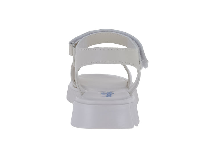 Sandalia blanca para niña con plataforma dentada, correa de ajuste y detalle acolchado en la parte frontal.