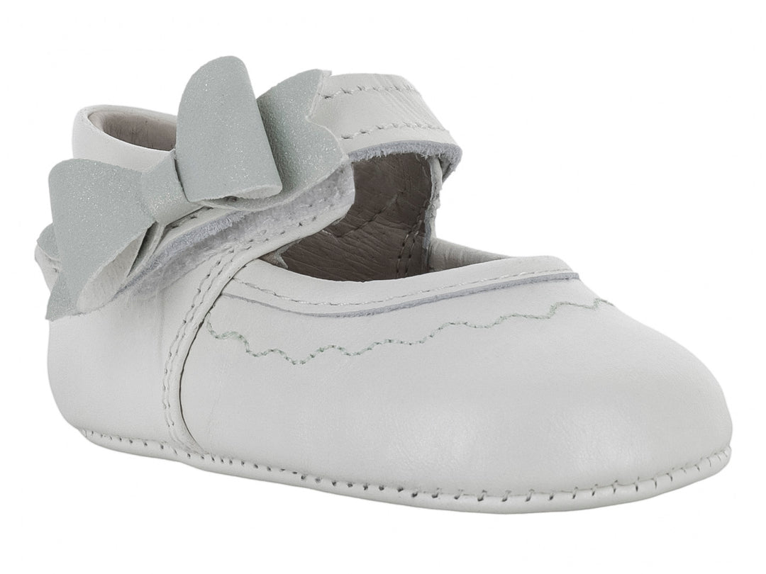 Zapato blanco para bebé con un moño decorativo en la parte superior.