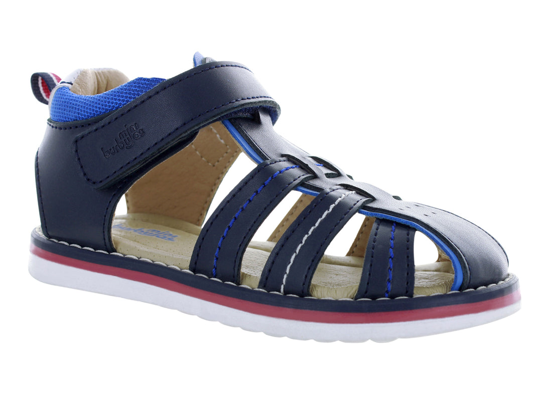 Sandalia infantil cerrada color azul marino con suela blanca y detalles en rojo y azul.