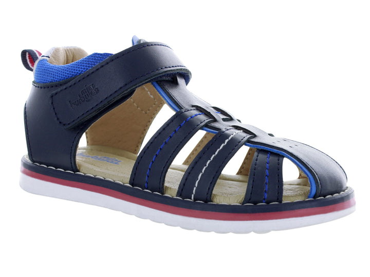 Sandalia infantil cerrada color azul marino con suela blanca y detalles en rojo y azul.