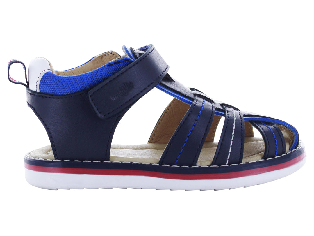 Sandalia infantil cerrada color azul marino con suela blanca y detalles en rojo y azul.