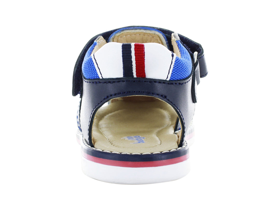 Sandalia infantil cerrada color azul marino con suela blanca y detalles en rojo y azul.