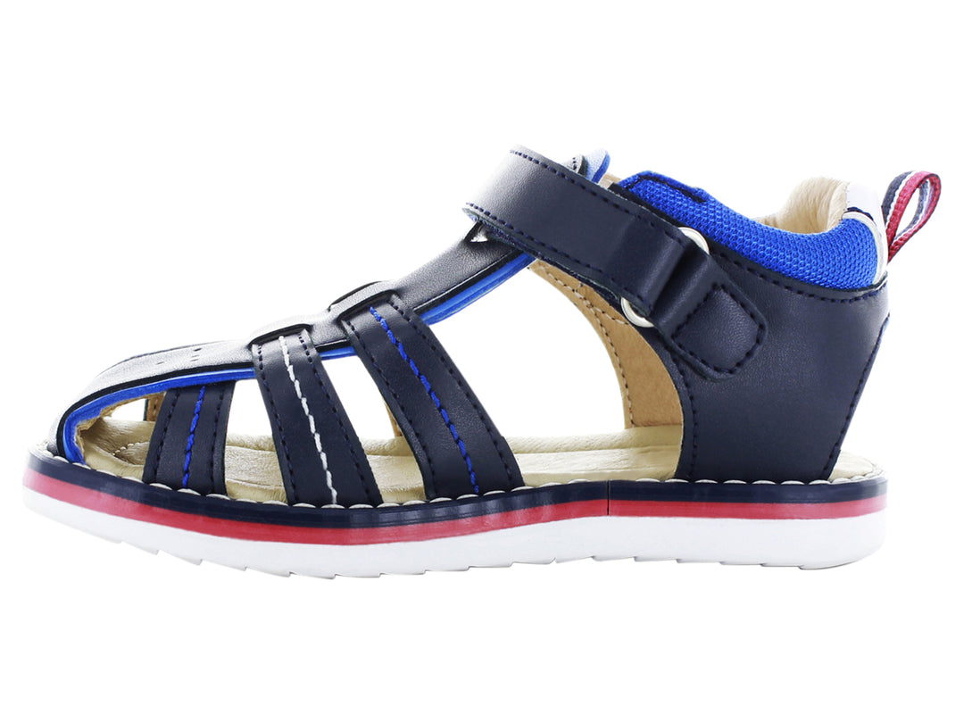 Sandalia infantil cerrada color azul marino con suela blanca y detalles en rojo y azul.
