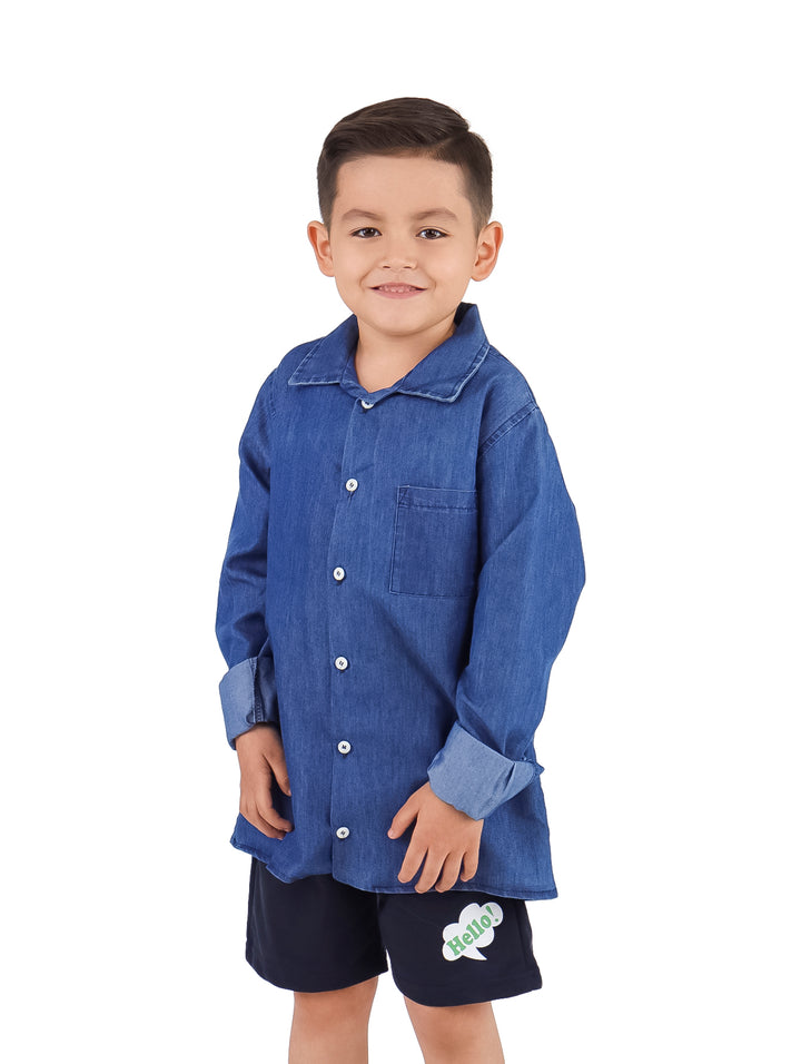 Niño vistiendo una camisa de mezclilla azul con botones y mangas remangadas.
