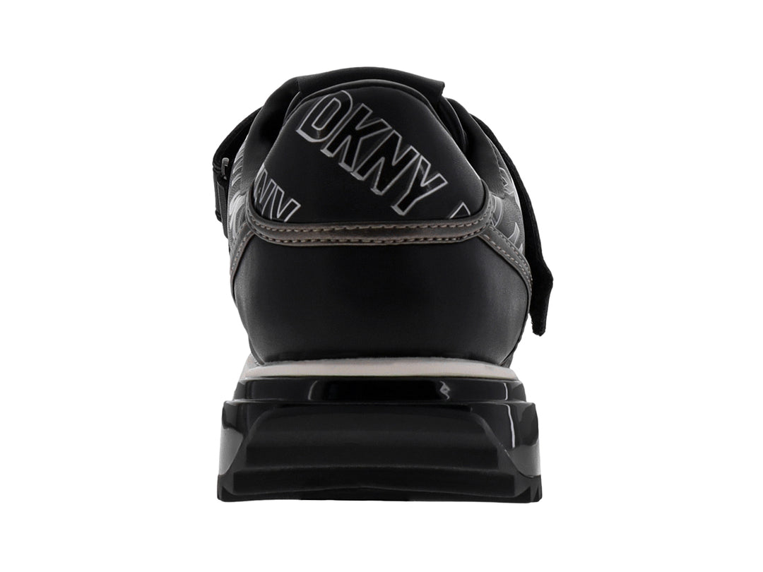 Tenis deportivos DKNY color negro y blanco con correa ajustable y suela blanca.