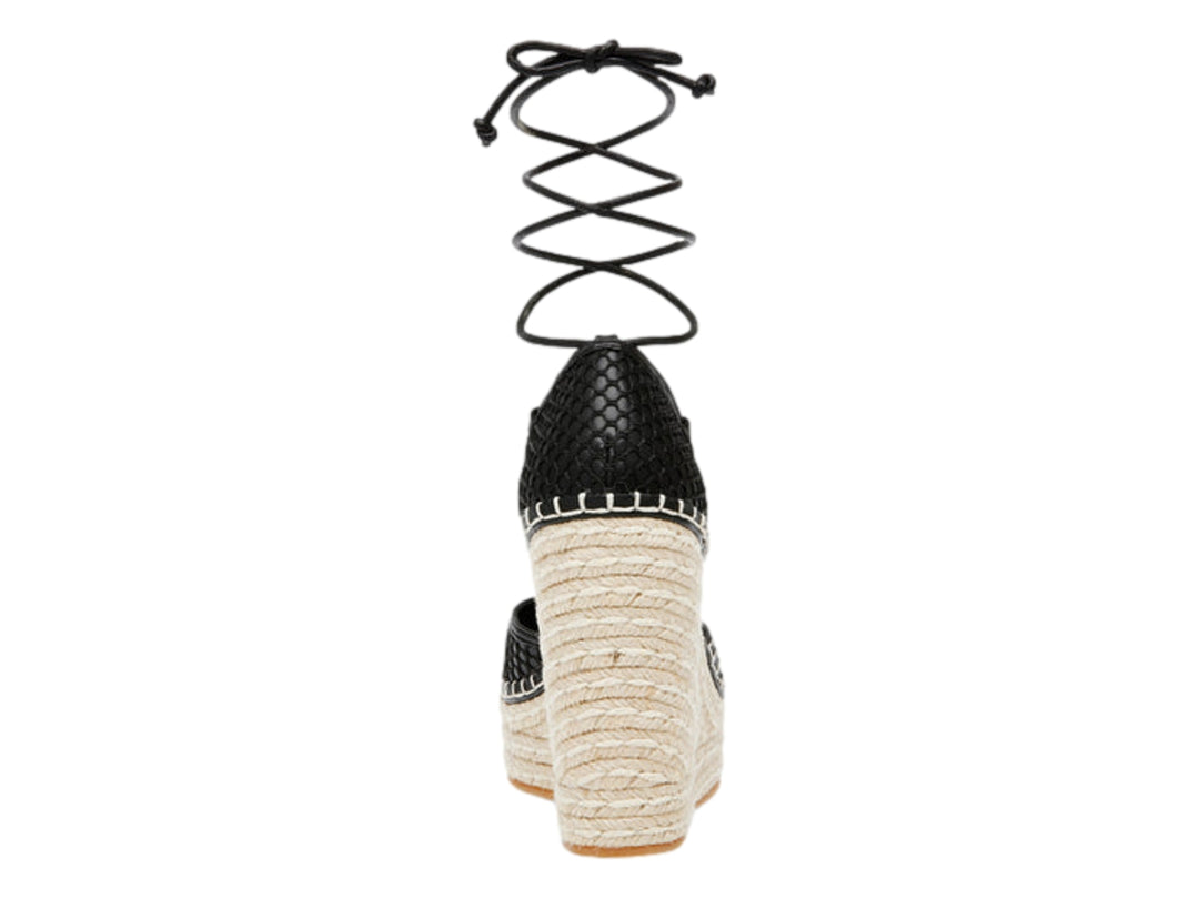 Sandalia de cuña negra con plataforma de esparto beige y cordones largos para amarrar al tobillo.
