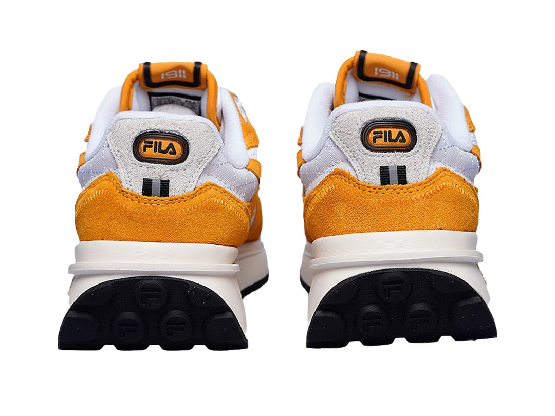 Tenis FILA modelo 1RM en colores amarillo azafrán y blanco con suela blanca y detalles deportivos.