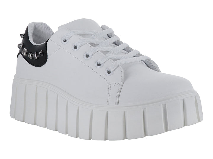 Tenis blancos de plataforma alta con detalle negro y tachuelas en el talón.