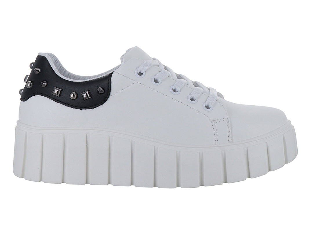 Tenis blancos de plataforma alta con detalle negro y tachuelas en el talón.