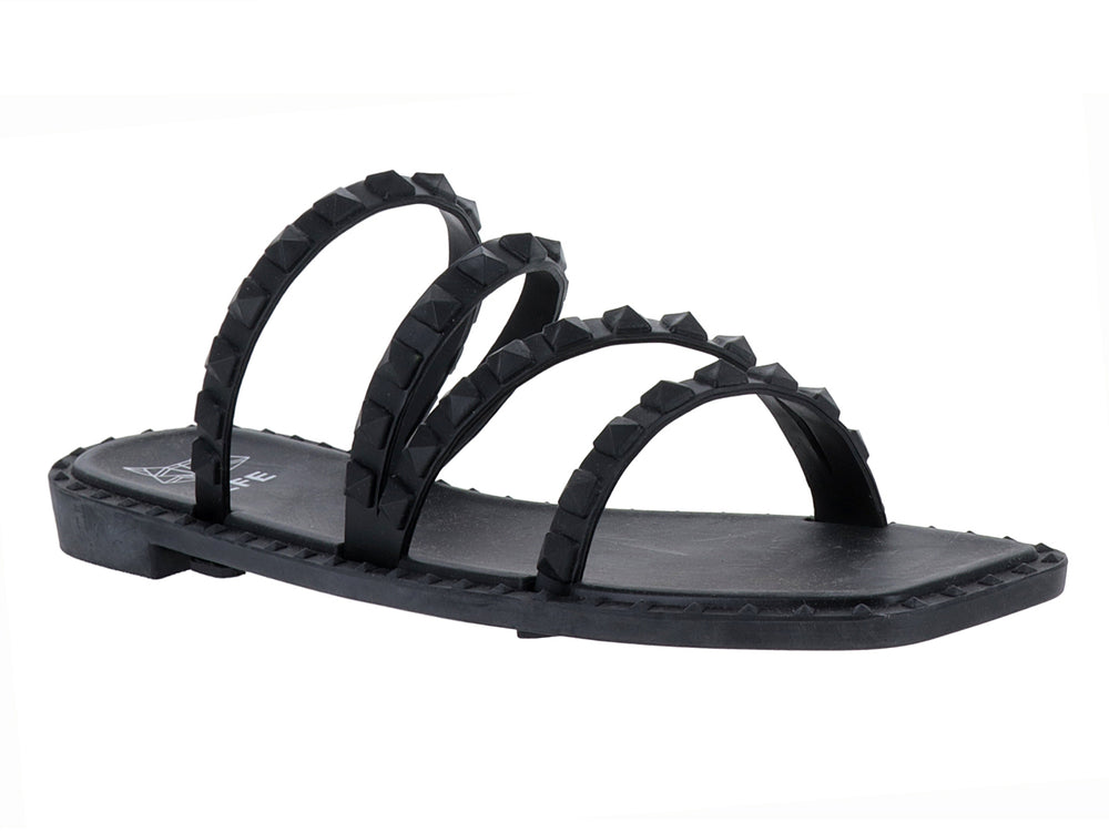 Sandalia plana color negro con cuatro correas decoradas con tachuelas negras.