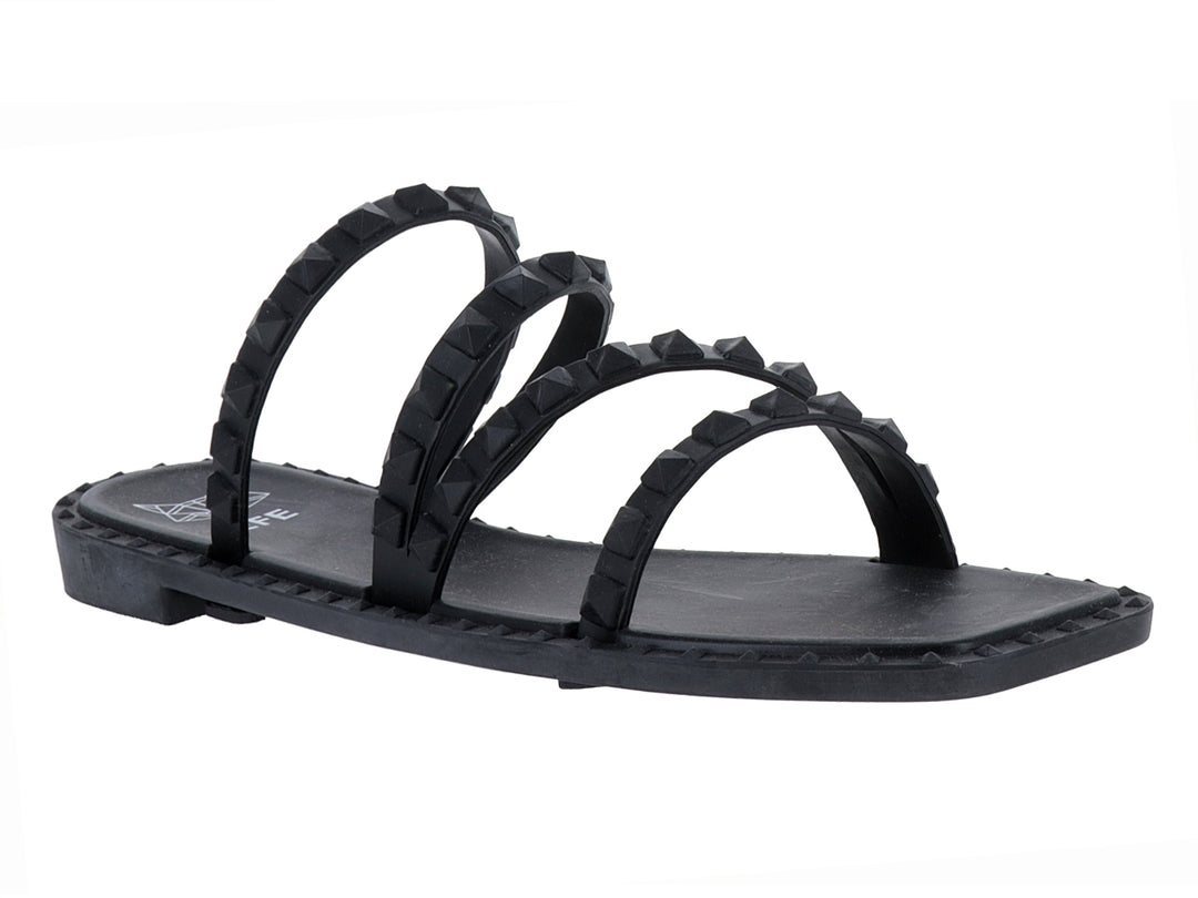 Sandalia plana color negro con cuatro correas decoradas con tachuelas negras.