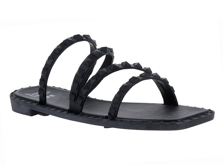 Sandalia plana color negro con cuatro correas decoradas con tachuelas negras.