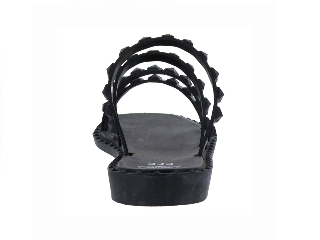 Sandalia plana color negro con cuatro correas decoradas con tachuelas negras.