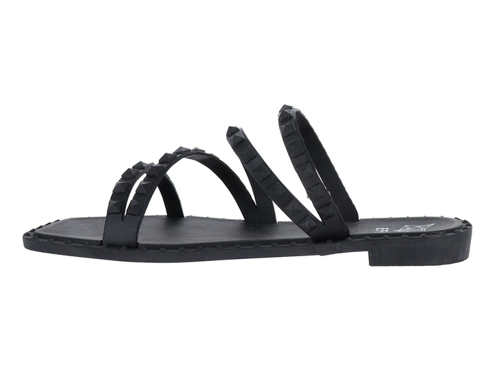 Sandalia plana color negro con cuatro correas decoradas con tachuelas negras.