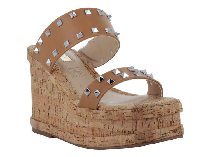 Sandalia de plataforma de corcho color beige con correas adornadas con tachuelas plateadas.