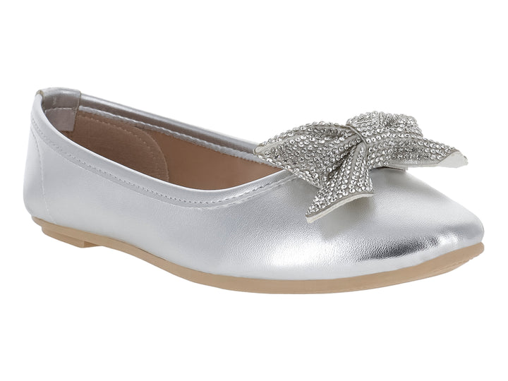Zapato plano color plata metálico con un moño decorativo brillante en la parte frontal.