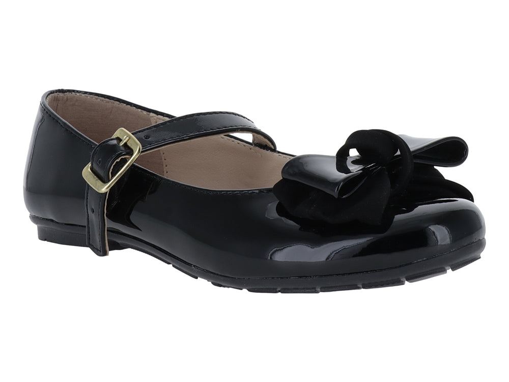 Zapato plano de charol negro con moño decorativo y correa con hebilla dorada.