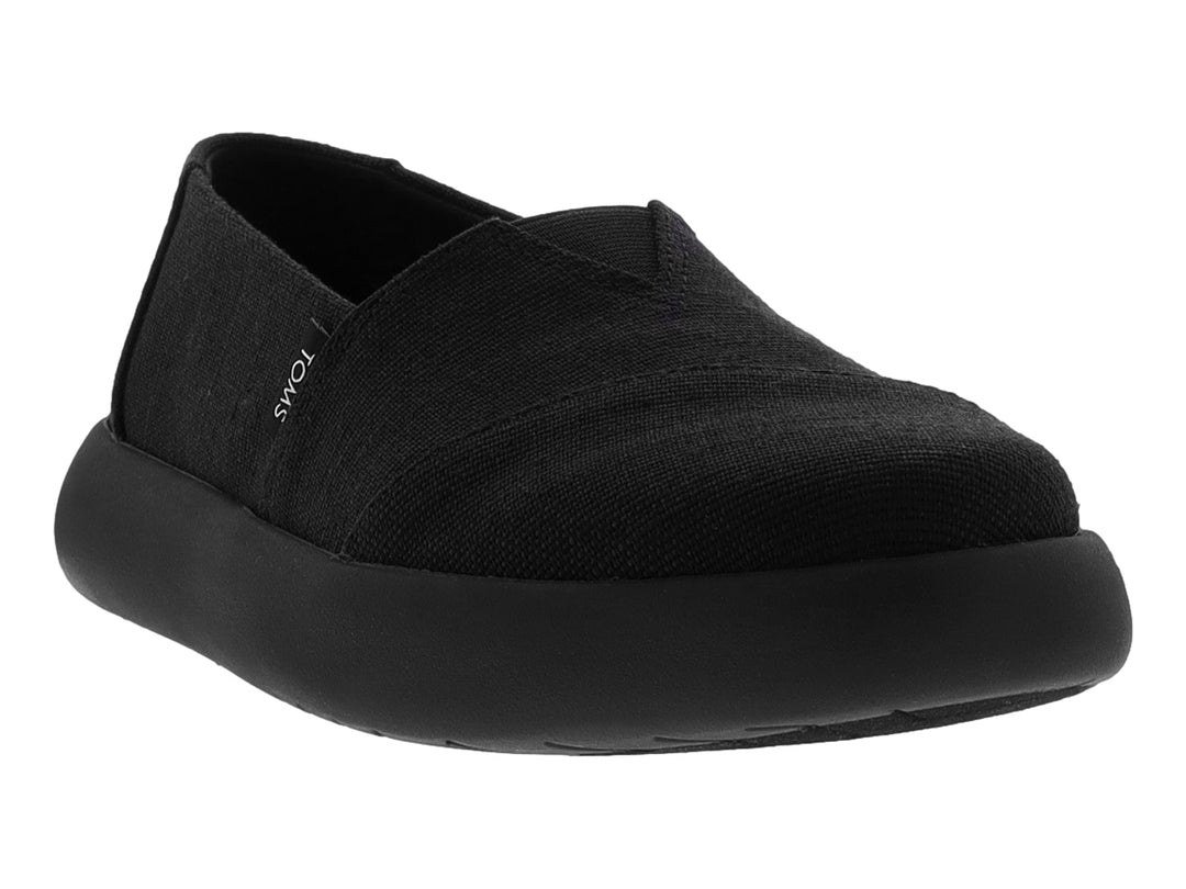 Zapato TOMS estilo slip-on en color negro total con suela ancha y material textil.