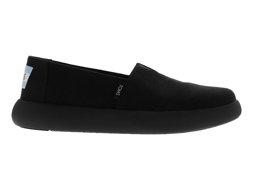 Zapato TOMS estilo slip-on en color negro total con suela ancha y material textil.