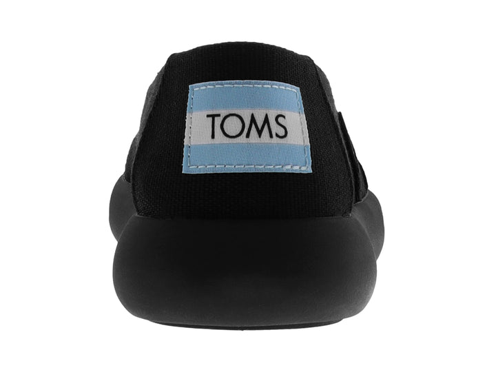 Zapato TOMS estilo slip-on en color negro total con suela ancha y material textil.