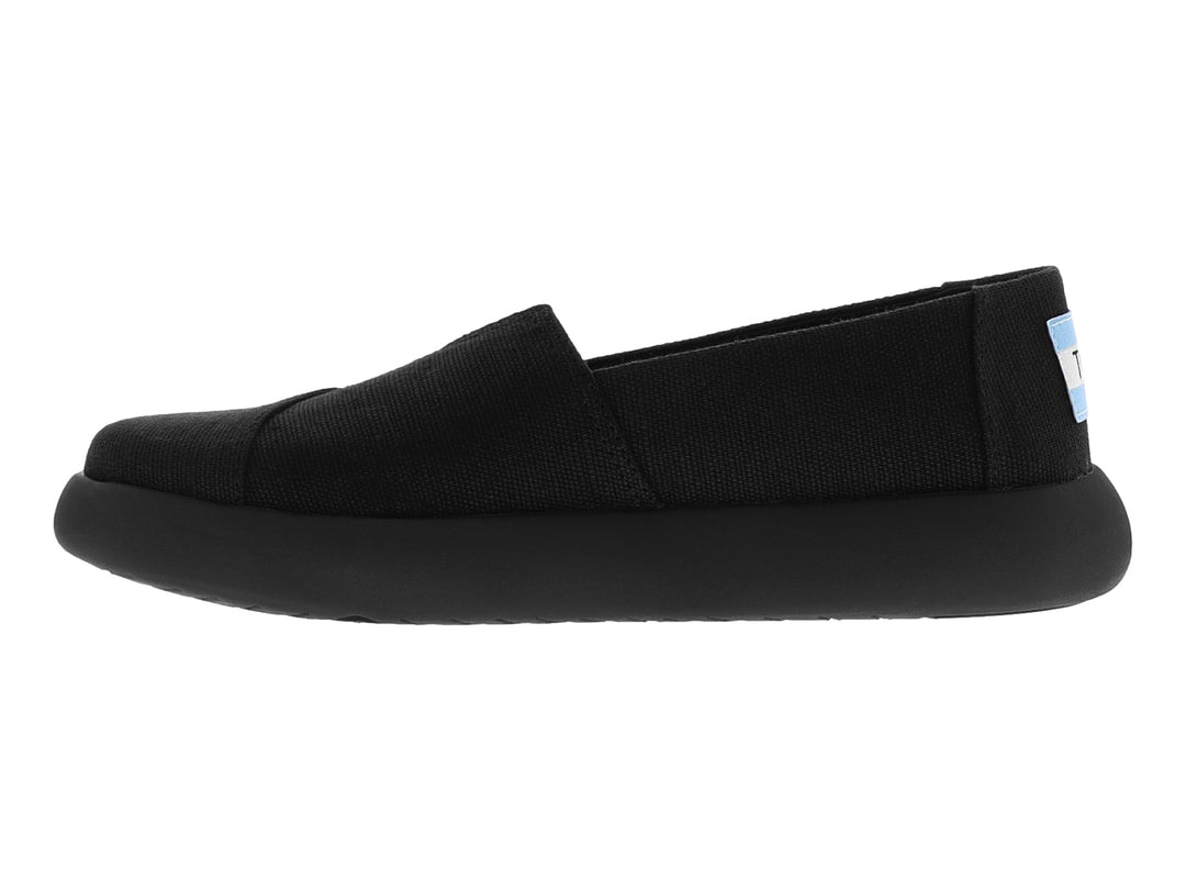 Zapato TOMS estilo slip-on en color negro total con suela ancha y material textil.