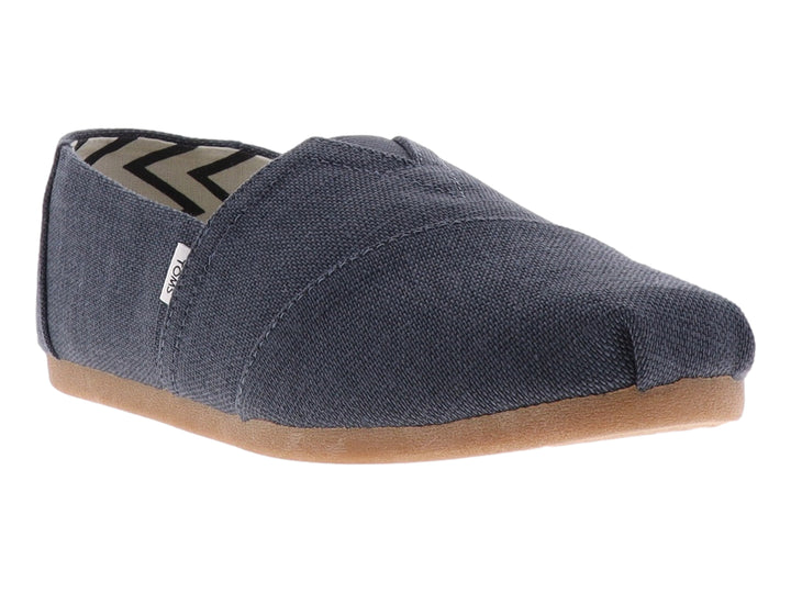 Zapato slip-on TOMS de color gris oscuro con suela color café y forro interior con patrón geométrico