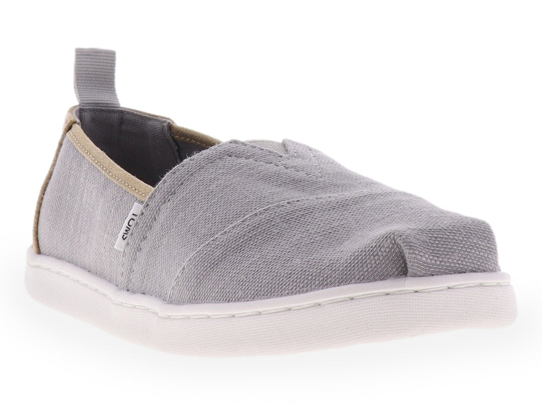Zapato slip-on TOMS color gris con suela blanca y tejido texturizado para niño.