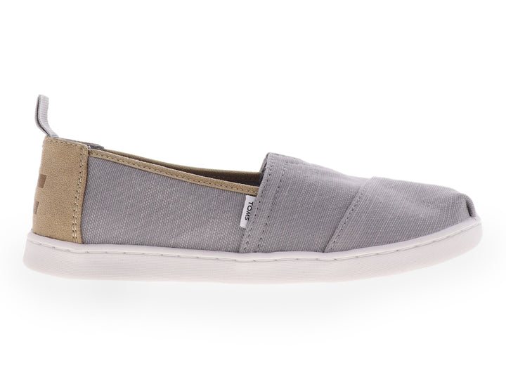 Zapato slip-on TOMS color gris con suela blanca y tejido texturizado para niño.