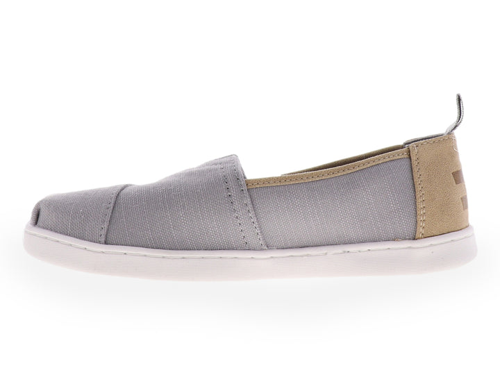 Zapato slip-on TOMS color gris con suela blanca y tejido texturizado para niño.