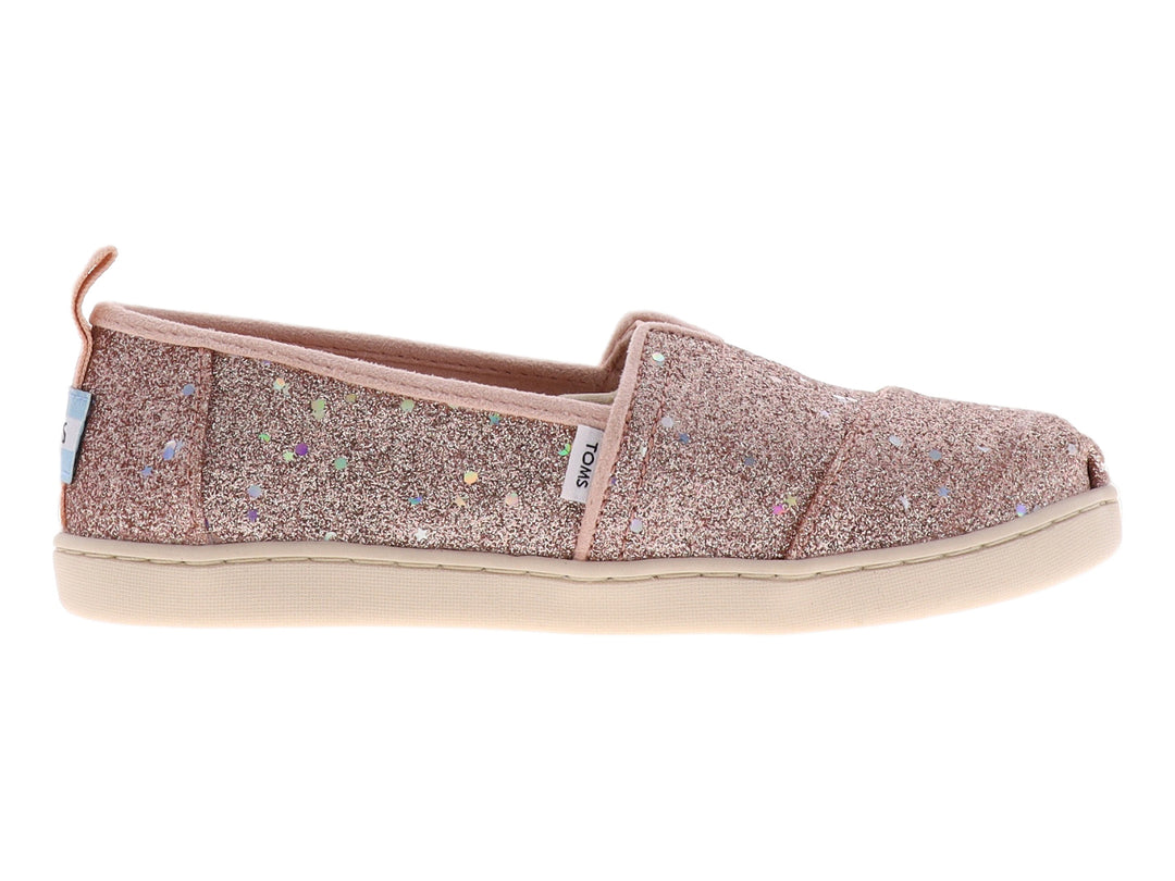 Zapato slip-on TOMS color oro rosa con acabado brillante y suela color crema.