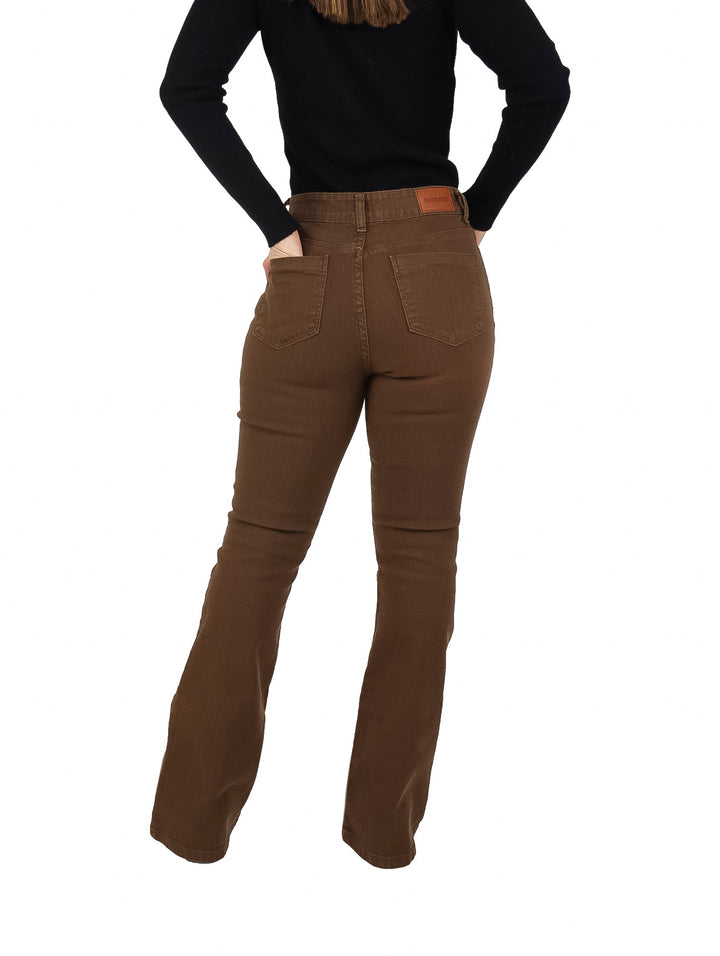 Mujer vistiendo pantalones jeans color capuchino de corte campana y blusa negra.