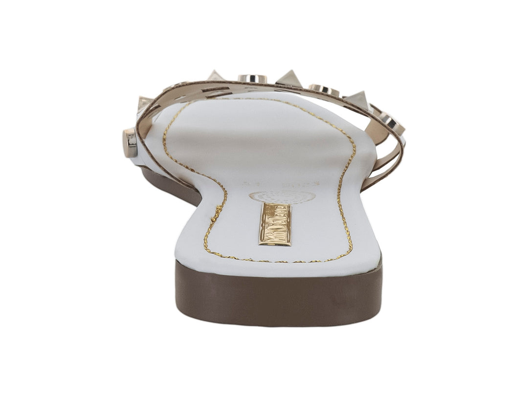 Sandalia blanca para mujer con tachuelas metálicas decorativas y suela plana.