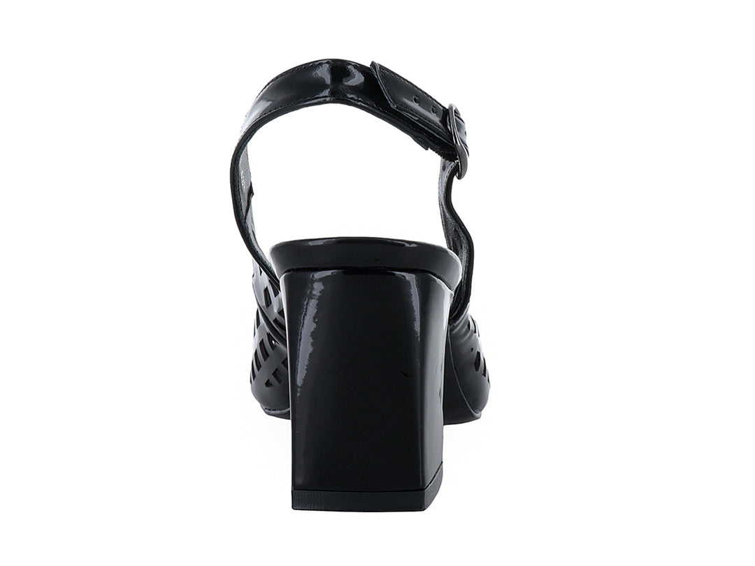Zapato negro de charol con tacón cuadrado, punta fina y diseño perforado con correa posterior.