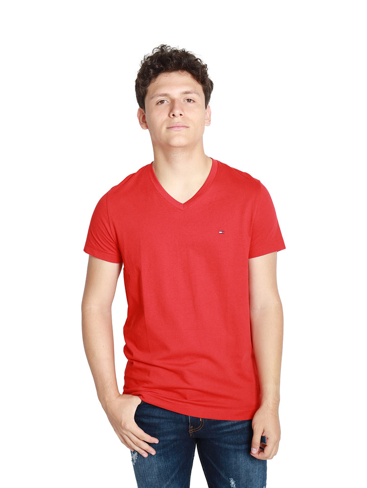Hombre vistiendo una camiseta roja de cuello en V y manga corta de la marca Tommy Hilfiger.