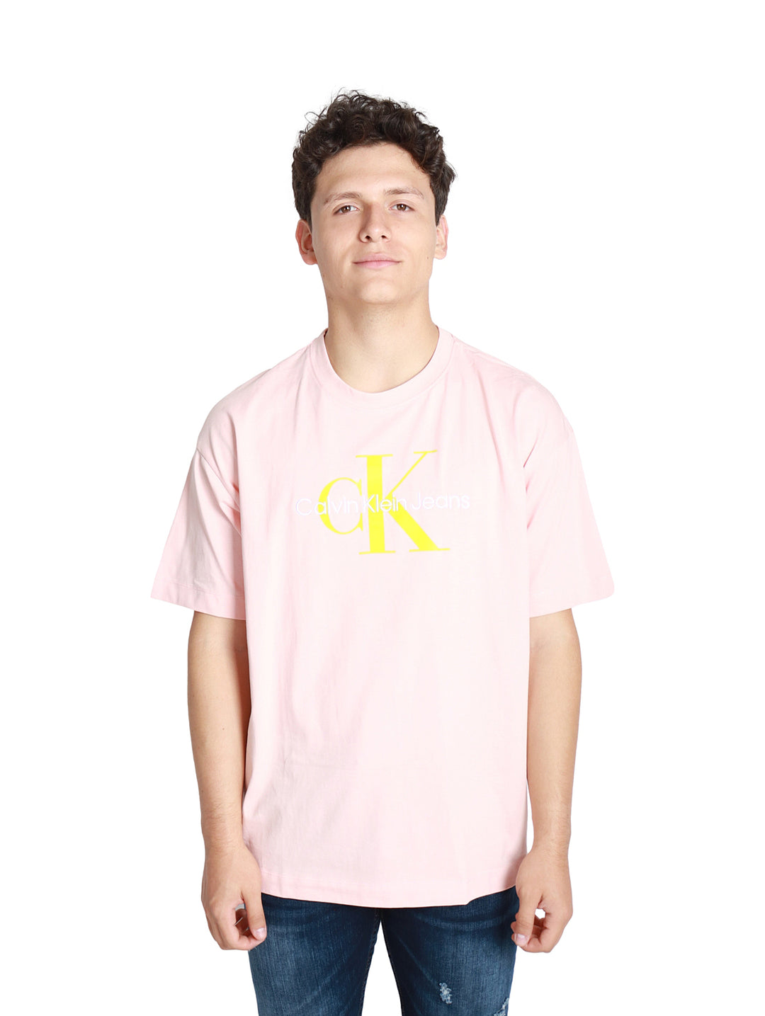 Hombre vistiendo camiseta rosa claro Calvin Klein con logotipo amarillo frontal.