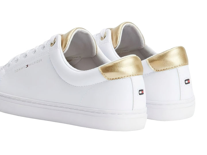 Tenis blancos de Tommy Hilfiger con detalles dorados en el talón y la lengüeta.
