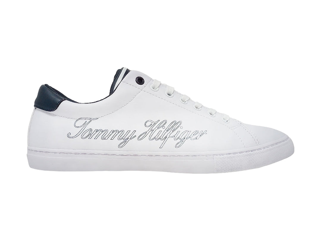 Tenis Tommy Hilfiger color blanco con detalles en azul marino y firma delineada en el costado.